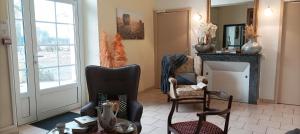a living room with two chairs and a fireplace at Rayon de sologne, Manoir 38 à 49 personnes 30 min zoo beauval, chambord, center parc in Langon +38 photos