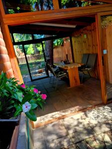 un porche grillagé avec une table et des chaises dans l'établissement RECI Beach Cottage, à Reci