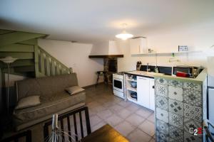 a living room with a couch and a kitchen at À la campagne in Cezay