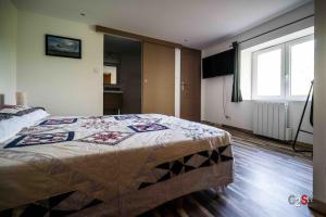 a bedroom with a bed with a quilt on it at À la campagne in Cezay