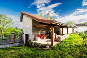 a house with a patio with a roof at À la campagne in Cezay