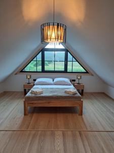 ein Schlafzimmer mit einem Bett und einem großen Fenster in der Unterkunft Drewno i Len in Debina