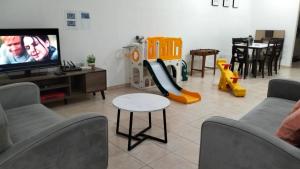 a living room with a tv and a play set at Westay Guest House in Melaka