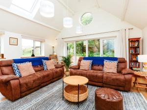 a living room with two brown couches and a table at Woodlands in Milverton