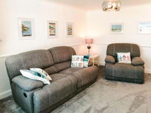 a living room with a couch and a chair at Beam Cottage in Flamborough