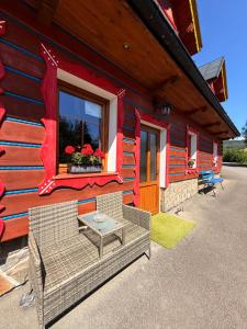 a building with a table and chairs outside of it at Penzión Stodola in Ždiar
