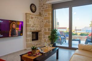 a living room with a tv on a stone wall at The Hospitality of the 11 Brothers in Kissamos