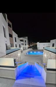 una piscina notturna con luci blu di Avis 2 a Igalo
