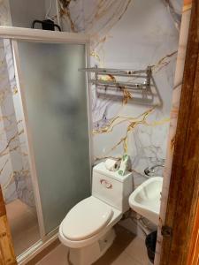 a bathroom with a white toilet and a sink at Curv Hotels minutes to Airport- Malls in Puerto Princesa City +58 photos