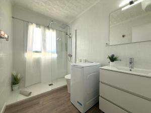 Un baño blanco con inodoro y lavabo. en amazing apt Playa del Cura, en Mogán 32 fotos más
