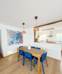 a dining room with a table and blue chairs at Chalet Vacacional ELIÁ -Piscina Privada, BBQ, Wifi in Chiclana de la Frontera +40 photos