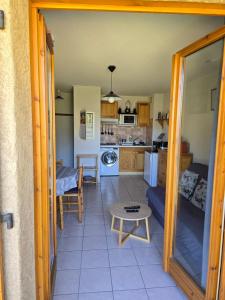 Il dispose d'une cuisine et d'un salon avec un canapé et une table. dans l'établissement Bel appartement à la Montagne, à Cervières 6 autres photos
