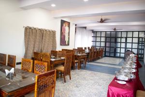 a dining room with wooden tables and chairs at Chauhan Sheraton Resort in Pushkar