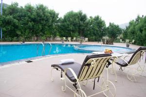 a pair of chairs sitting next to a swimming pool at Chauhan Sheraton Resort in Pushkar