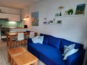 a living room with a blue couch and a table at Van der Molen in Innerkrems