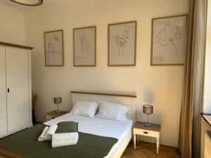 a bedroom with a bed with four pictures on the wall at Nature-Inspired Stay in Piata Sfatului Brasov in Braşov