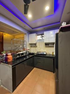 a kitchen with black counters and a purple ceiling at Waterfront Homestay 2BHK Free Bonfire By Homeyhuts in Mandi