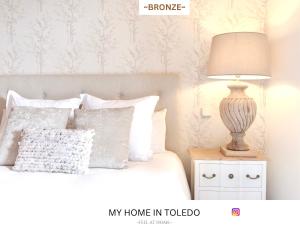 a bedroom with a bed with a lamp on a night stand at -BRONZE- by myhomeintoledo in Toledo