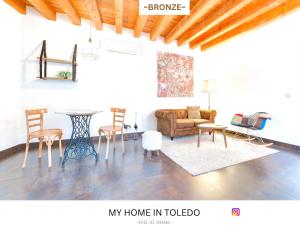 a living room with a couch and a table and chairs at -BRONZE- by myhomeintoledo in Toledo