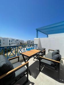 a patio with a table and chairs on a balcony at Boho Breez Mountain View Chalet in Ras Elhekma