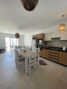 a kitchen and dining room with a table and chairs at Boho Breez Mountain View Chalet in Ras Elhekma