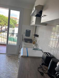 een kamer met een keuken met een wastafel en een raam bij Appartement entier in Aubenas