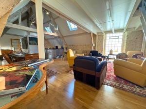a living room with couches and chairs in a building at Le Loft de Montfort coeur de ville in Montfort-lʼAmaury
