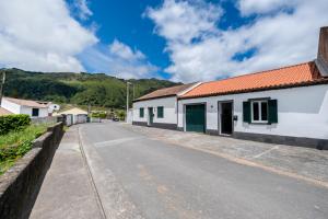 an empty street next to a white building at Blue Tile Home in Furnas