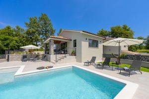 a swimming pool in front of a house at Villa Nik by Istrialux in Svetvinčenat