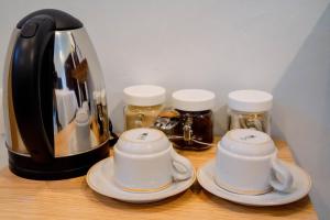a counter with two tea cups and a coffee pot at Fantasticroom Labuan Bajo in Labuan Bajo