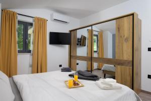 a bedroom with a white bed with a large mirror at Villa Nik by Istrialux in Svetvinčenat +56 photos