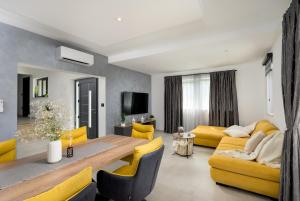 a living room with a table and yellow chairs at Villa Nik by Istrialux in Svetvinčenat