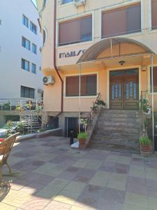 a building with a wooden door and stairs in front at Marisol in Eforie Nord