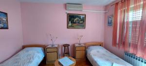 two twin beds in a room with pink walls at Mirna noć, soba s 2 odvojena kreveta in Zagreb