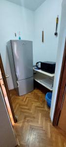 a kitchen with a stainless steel refrigerator in a room at Mirna noć, soba s 2 odvojena kreveta in Zagreb