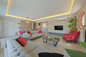 ein Wohnzimmer mit einem großen Sofa und roten Stühlen in der Unterkunft VillaSerenity5 in Fethiye
