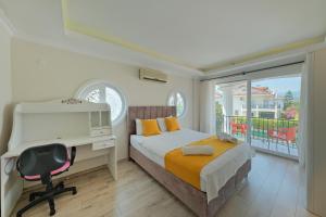 ein Schlafzimmer mit Bett und Schreibtisch und ein Balkon in der Unterkunft VillaSerenity5 in Fethiye + 27 Fotos