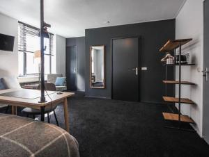 a room with a bed and a desk and a table at Boutique Hotel Pake Klaas in Sneek
