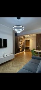 a living room with a couch and a television at Aparthotel Madonna Residence Petunilor in Craiova