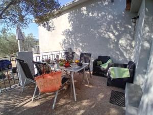 a table and chairs sitting on a patio at La maison sous les oliviers Casa d'Iloa in Porto-Vecchio