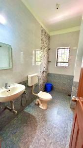 a bathroom with a toilet and a sink at Bright Beach Homestays in Calangute