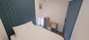 a bedroom with a white bed and a blue wall at Charmant logement indépendant avec patio in Niort