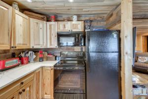 a kitchen with a stainless steel refrigerator and wooden cabinets at Pequot Lakes Cabin with Dock on Loon Lake! in Pequot Lakes +20 photos