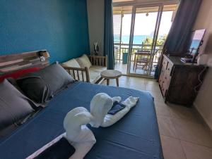 a bedroom with a blue bed with swans on it at La Kaz a lò in Le Diamant
