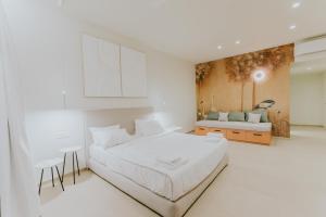a white bedroom with a bed and a couch at The Palms Concept Hotel Adults Only 16 Plus in Faliraki +122 photos