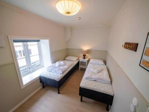 two beds in a small room with a window at Lofoten Summer Apartments in Kabelvåg +24 photos