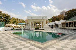 a swimming pool in a courtyard with a building at Gulbag Heritage in Jaipur