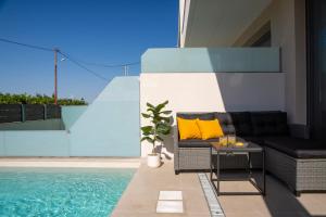 a patio with a couch next to a swimming pool at Elysian Luxury Suite in Preveza