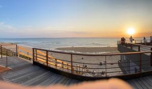 a view of the beach at sunset from a boardwalk at Les ptis chiffons in Lacanau
