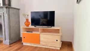 a tv on a wooden stand with a television on it at 201 Loft Lumineux en Hyper-Centre in Liège